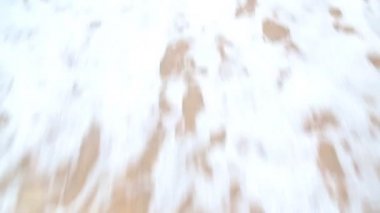 Dalgalar üzerinde beyaz kum yıkama