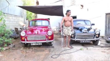 Eski arabaları yıkayan adam.