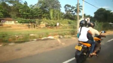 Hareket eden bir arabanın üzerinden yetişme motosikletçi