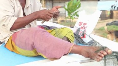 Balıkçı teknesinde oturan ve balık ağlarına sabitleme