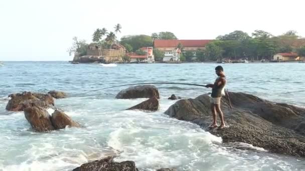 Pêcheur pêchant depuis un rocher — Video