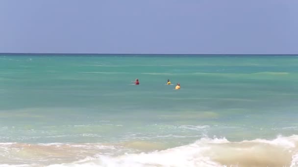 มุมมองของคลื่นบนชายหาดฮิกคาดูวาในขณะที่นักโต้คลื่นกําลังเพลิดเพลินกับมหาสมุทร — วีดีโอสต็อก