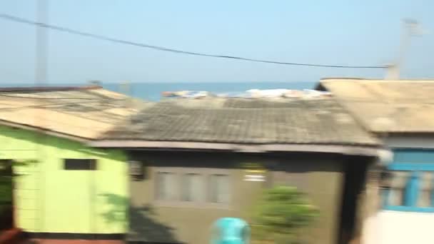 Blick vom vorbeifahrenden Zug auf die Vororte am Meer — Stockvideo