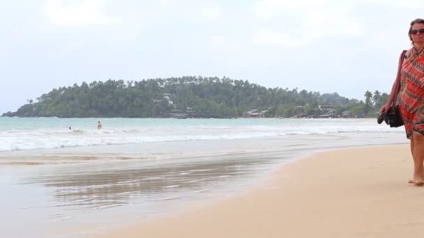 Tourist walking by on beach — Stock Video