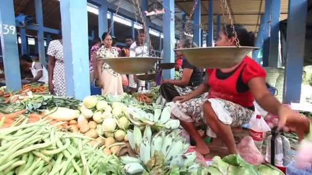 Young local woman selling and people buying at Hikkaduwa market — Stock Video