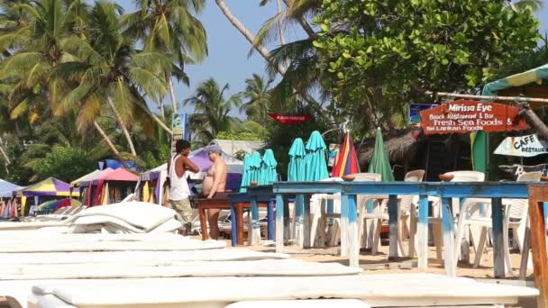 Homme préparant des chaises longues pour les touristes — Video