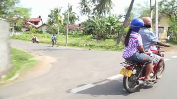 Man and woman riding motorcycle in Weligama. — Stock Video