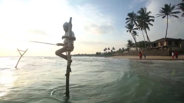 Pescador em um pólo de pesca no oceano — Vídeo de Stock