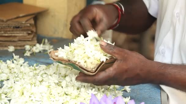 Hands making flower arrangements for temple — Stock Video