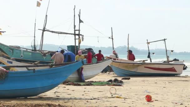 Rybáři třídění sítí na pláži po dlouhé noci pracovní. — Stock video