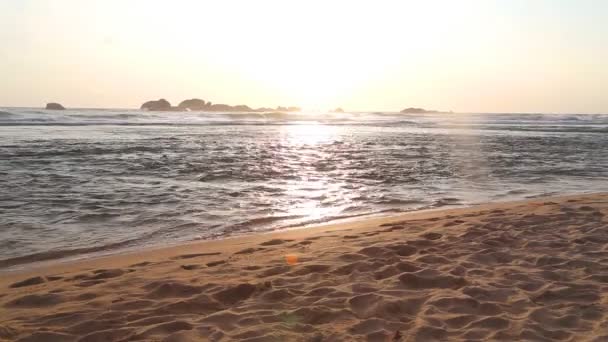 Meerblick in Hikkaduwa bei Sonnenuntergang mit Wellen, die den Strand bespritzen. — Stockvideo