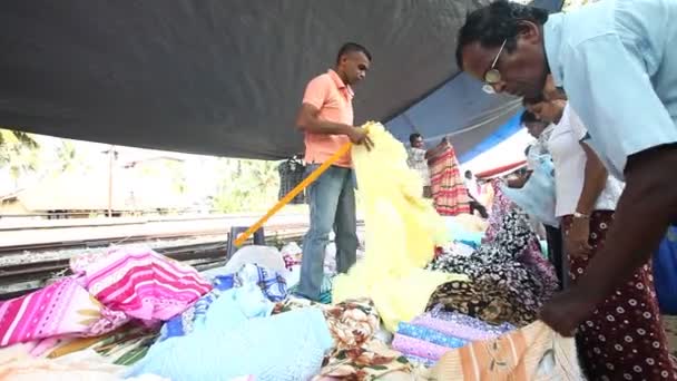 Penjual menunjukkan dan mengatur tekstil — Stok Video