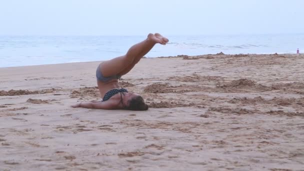 Woman stretching out on the beach — Stock Video