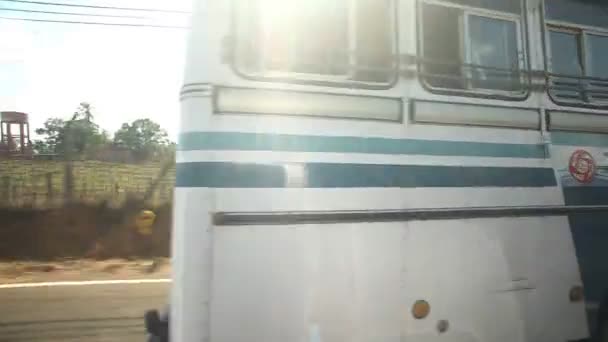 Минивэн обгоняет автобус по маленьким проселочным дорогам — стоковое видео