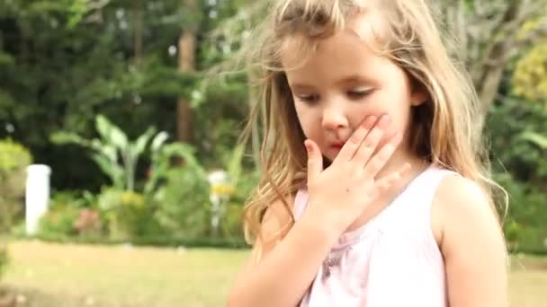 Mädchen spielt mit Mütze im Garten — Stockvideo