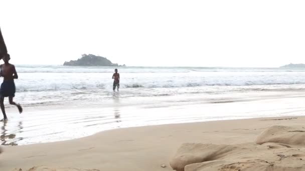 Blick auf den Ozean in Weligama mit Menschen, die die Wellen genießen — Stockvideo