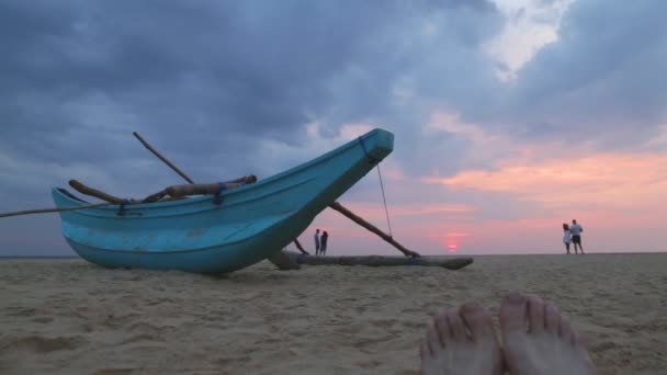 Boot op Hikkaduwa strand bij zonsondergang met mensen nemen foto — Stockvideo