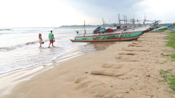 The view of boats on the beach in Weligama with people passing by — Stock Video