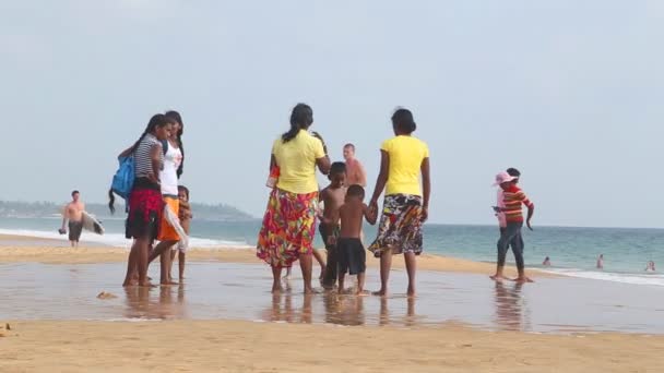 Locales disfrutando de la playa y jugando en el surf . — Vídeo de stock