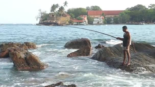 Pêcheur pêchant depuis un rocher — Video