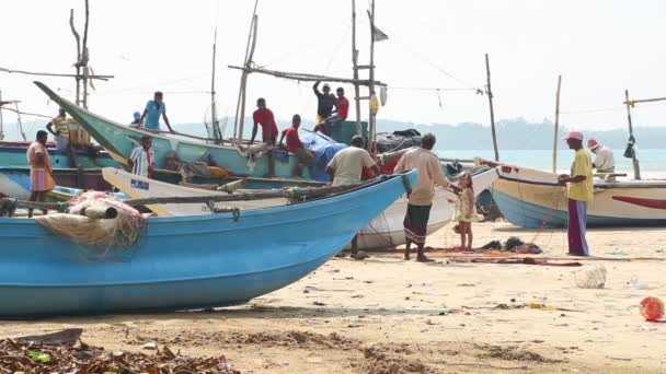 Pescadores locales clasificando redes en la playa después de una larga noche de trabajo . — Vídeos de Stock