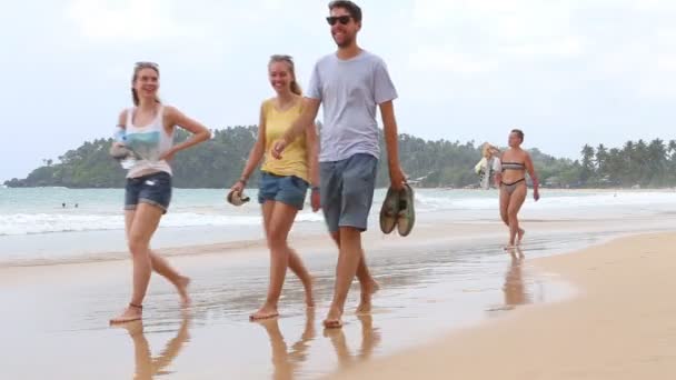 Touristen spazieren am Strand vorbei — Stockvideo