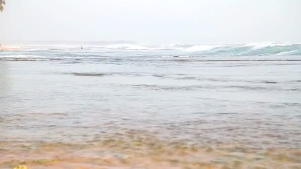 Meerblick in Hikkaduwa bei Sonnenuntergang mit Wellen, die den Strand bespritzen. — Stockvideo