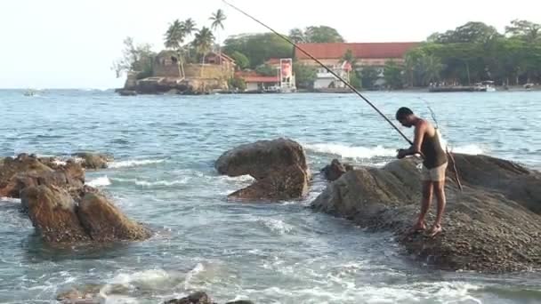 Pêcheur pêchant depuis un rocher — Video