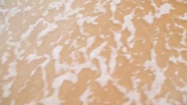 Dalgalar üzerinde beyaz kum yıkama