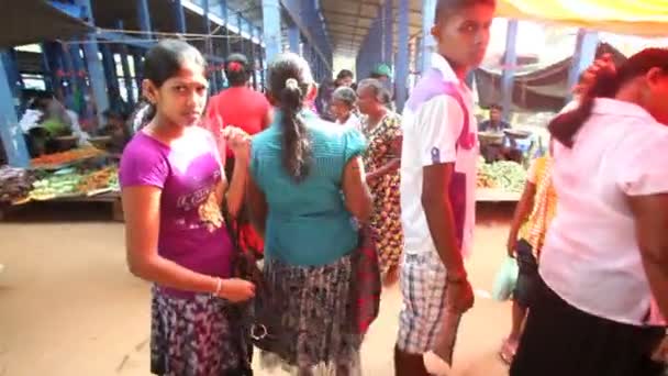 Local woman passing by and browsing at Hikkaduwa market — Stock Video