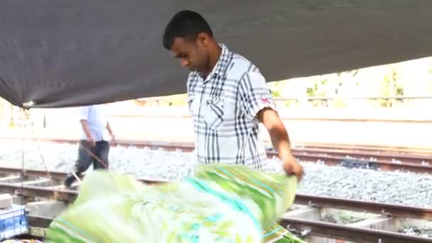Homem local organizando têxteis — Vídeo de Stock