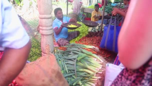 Человек взвешивает и продает свою продукцию — стоковое видео