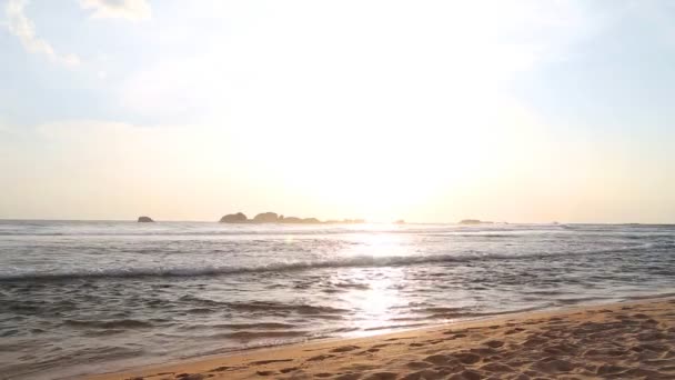 Meerblick in Hikkaduwa bei Sonnenuntergang mit Wellen, die den Strand bespritzen. — Stockvideo