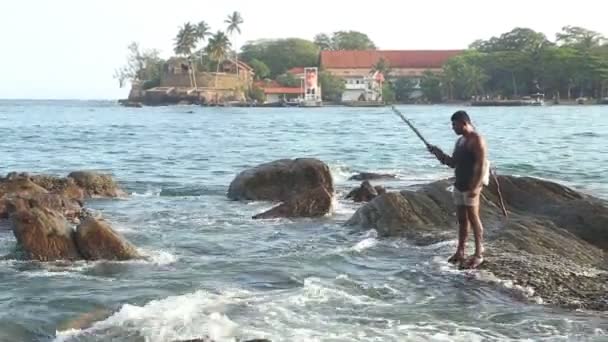 Pêcheur pêchant depuis un rocher — Video