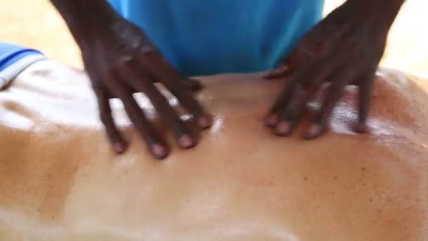 Sri Lanki człowiek daje niższe powrót oleju masażu do kaukaski mężczyzna — Wideo stockowe