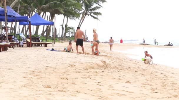 Touristen spielen am Strand mit Sand — Stockvideo