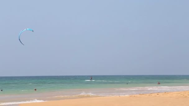 Hombre cometa surf desde la playa de arena . — Vídeo de stock