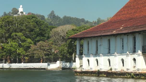 Weergave van huis aan Kandy meer met Boeddhabeeld in achtergrond. — Stockvideo