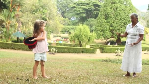 Mujer jugando con chica en el jardín — Vídeos de Stock