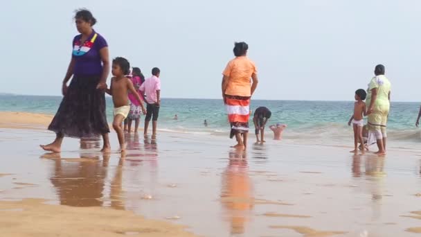 Locals enjoying the beach and playing in the surf. — Stock Video