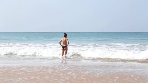 Женщина входит в море в волнах в Mirissa — стоковое видео