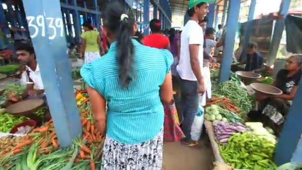 Local woman passing by and browsing at Hikkaduwa market. — Stock Video