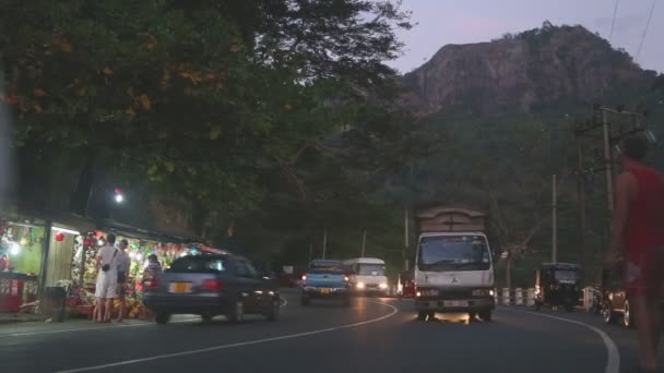 Route de Kandy avec de nombreux stands de rue et une circulation dense dans la soirée . — Video