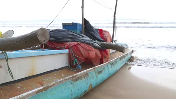 Лодка на пляже в Велигаме с серферами, проходящими мимо — стоковое видео