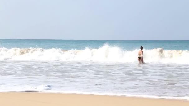 Vrouw zee invoeren in de golven in Mirissa — Stockvideo