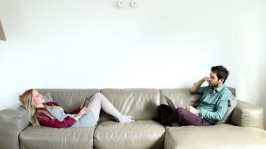 Çift konuşma ve kanepenin üstünde istimal bilgisayar