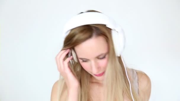 Kvinna som lyssnar på musik med vita hörlurar — Stockvideo