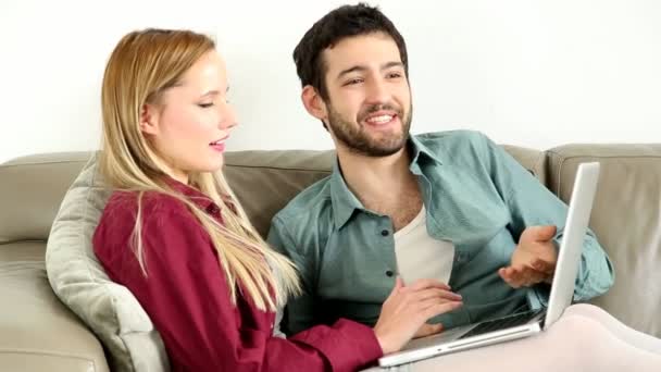 Pareja mirando portátil en casa — Vídeo de stock