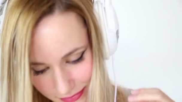 Mujer escuchando música con auriculares blancos — Vídeo de stock