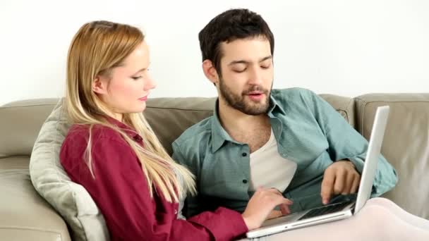 Пара смотрит на ноутбук дома — стоковое видео